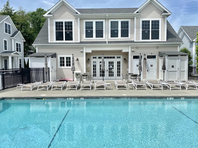 159 Colonial Rd Unit 5, Stamford, CT 06906 - rear view of house featuring french doors, a community pool, and roof with shingles