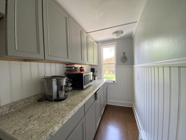 114 Pulaski St, Torrington, CT 06790 - kitchen featuring stainless steel microwave, dark wood-style flooring, light countertops, wainscoting, and a decorative wall