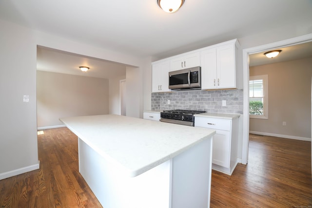 30 Ward Pl, West Haven, CT 06516 - kitchen with appliances with stainless steel finishes, dark wood-style flooring, tasteful backsplash, white cabinets, and a center island