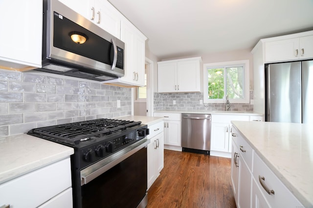 30 Ward Pl, West Haven, CT 06516 - kitchen with appliances with stainless steel finishes, light stone countertops, white cabinetry, backsplash, and dark wood-style flooring