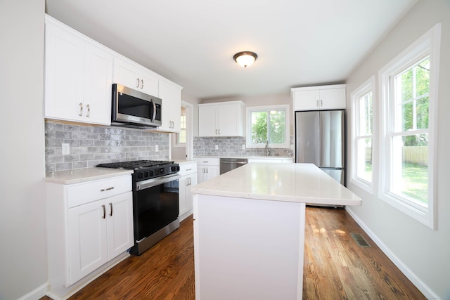 30 Ward Pl, West Haven, CT 06516 - kitchen with appliances with stainless steel finishes, dark wood-style floors, backsplash, and light countertops