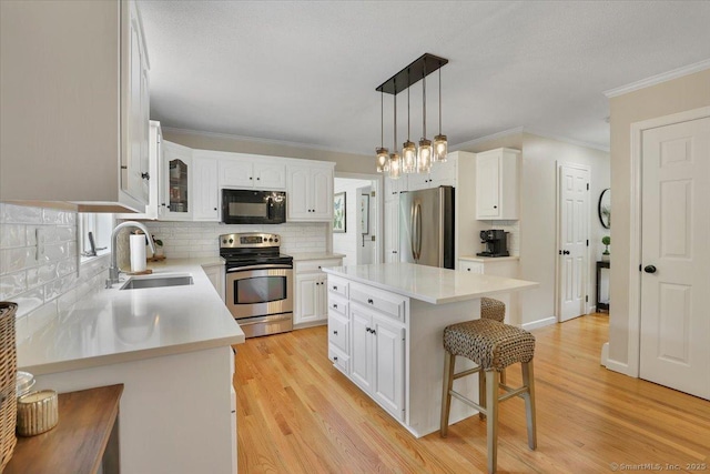 15 Thompson Hill Rd, Canton, CT 06019 - kitchen featuring appliances with stainless steel finishes, a kitchen bar, decorative backsplash, white cabinets, and ornamental molding