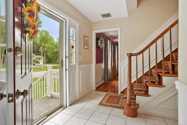 58 Inca Dr, Trumbull, CT 06611 - tiled foyer with a baseboard heating unit, a wainscoted wall, stairway, and a decorative wall