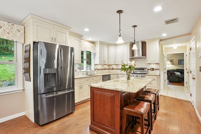58 Inca Dr, Trumbull, CT 06611 - kitchen with appliances with stainless steel finishes, wall chimney exhaust hood, backsplash, light stone countertops, and a kitchen island