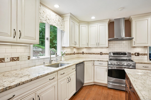 58 Inca Dr, Trumbull, CT 06611 - kitchen with stainless steel appliances, wall chimney range hood, light wood-style flooring, light stone counters, and backsplash