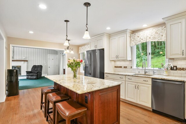 58 Inca Dr, Trumbull, CT 06611 - kitchen featuring stainless steel appliances, backsplash, light stone counters, a kitchen bar, and recessed lighting