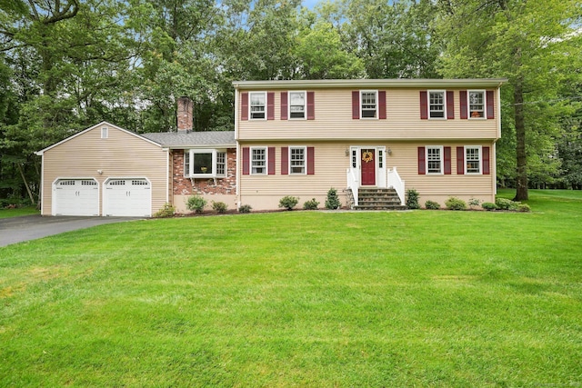 58 Inca Dr, Trumbull, CT 06611 - colonial home with a chimney, driveway, an attached garage, a front lawn, and view of wooded area