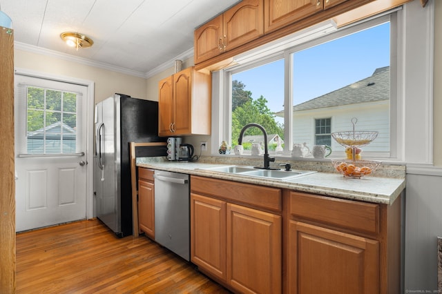 89 Geer Ave, Norwich, CT 06360 - kitchen with appliances with stainless steel finishes, light wood finished floors, crown molding, brown cabinets, and light stone counters