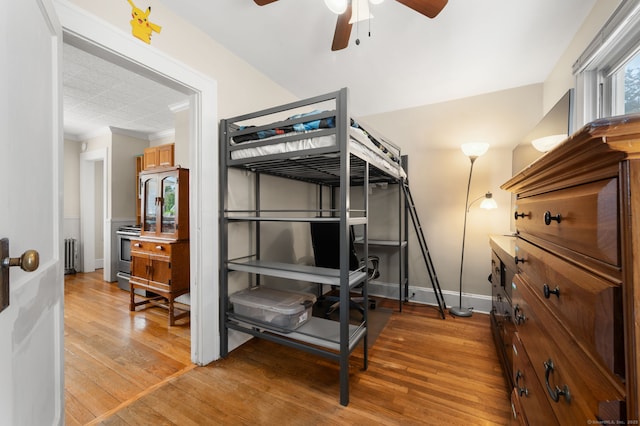 89 Geer Ave, Norwich, CT 06360 - bedroom with radiator heating unit, light wood finished floors, crown molding, and ceiling fan