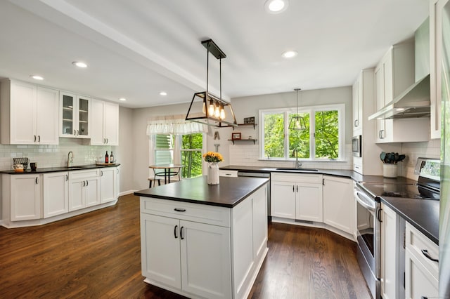 28 Saddle Ridge Dr, Simsbury, CT 06092 - kitchen featuring stainless steel appliances, dark countertops, wall chimney exhaust hood, decorative backsplash, and white cabinets