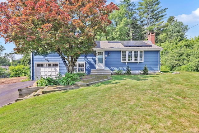 39 Alder Rd, Simsbury, CT 06070 - view of front of home with a chimney, roof mounted solar panels, driveway, and a front lawn