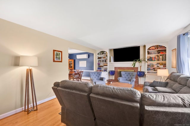 39 Alder Rd, Simsbury, CT 06070 - living area featuring light wood finished floors, built in features, a fireplace, and a wall unit AC
