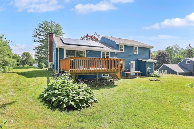 39 Alder Rd, Simsbury, CT 06070 - rear view of house featuring a chimney, roof mounted solar panels, a deck, and a yard