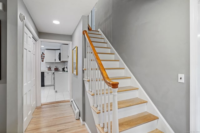 17 Mail Coach Dr, Norwalk, CT 06850 - staircase featuring baseboard heating, wood finished floors, and recessed lighting