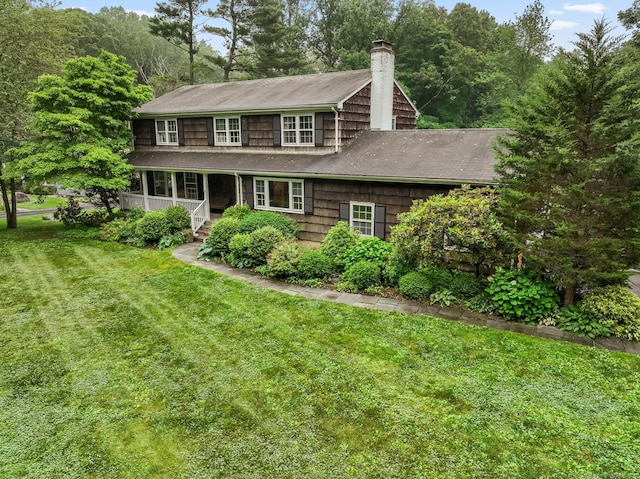 17 Mail Coach Dr, Norwalk, CT 06850 - view of front of home featuring a chimney, a front yard, a porch, and a shingled roof