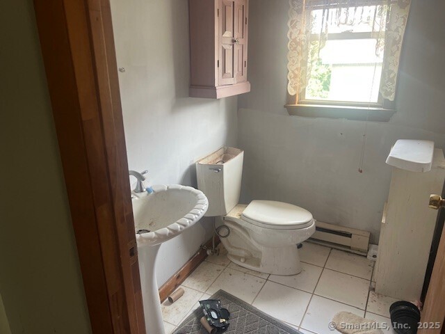 51 N Cliff St, Norwich, CT 06360 - half bath with a baseboard heating unit and tile patterned flooring