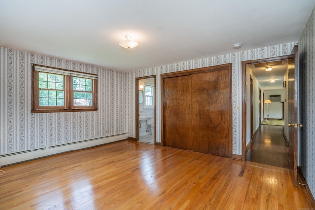 62 Eddy Ln, Newington, CT 06111 - unfurnished bedroom with wallpapered walls, a baseboard heating unit, light wood finished floors, a closet, and connected bathroom
