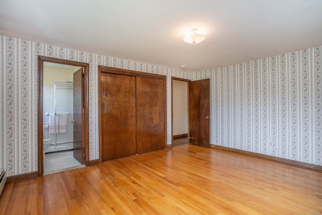 62 Eddy Ln, Newington, CT 06111 - unfurnished bedroom with wallpapered walls, wood finished floors, a closet, connected bathroom, and a baseboard radiator