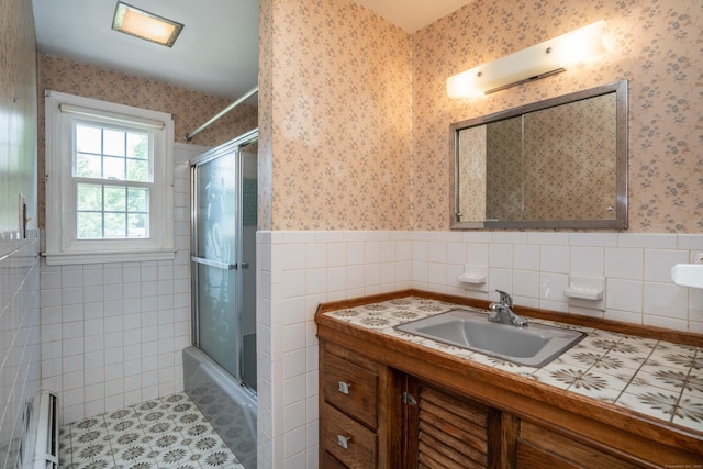 62 Eddy Ln, Newington, CT 06111 - full bath featuring wallpapered walls, vanity, wainscoting, tile walls, and combined bath / shower with glass door