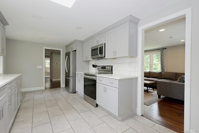 3743 Park Ave, Fairfield, CT 06825 - kitchen featuring stainless steel appliances, light countertops, backsplash, light tile patterned flooring, and recessed lighting