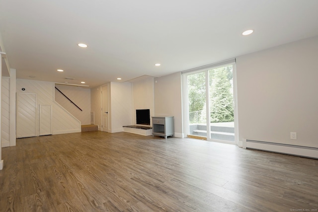 3743 Park Ave, Fairfield, CT 06825 - unfurnished living room featuring a baseboard heating unit, stairway, wood finished floors, recessed lighting, and a wall of windows