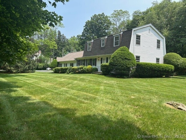 147 Beers Rd, Easton, CT 06612 - view of front of home with a gambrel roof, a front lawn, roof with shingles, and view of wooded area