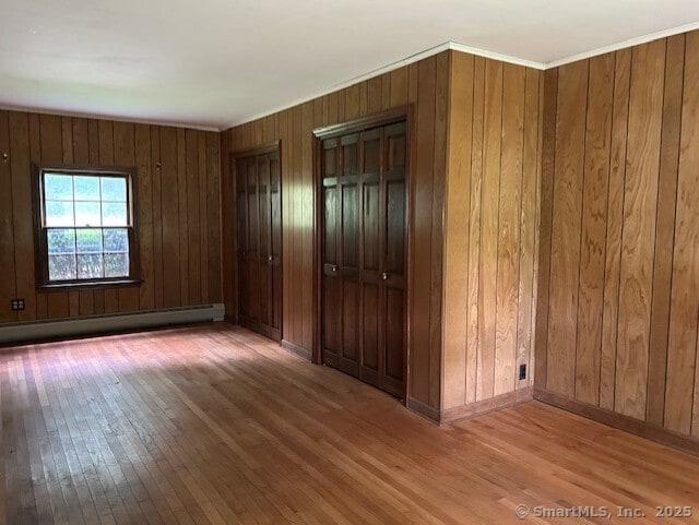 147 Beers Rd, Easton, CT 06612 - empty room with wood-type flooring, a baseboard radiator, and wood walls