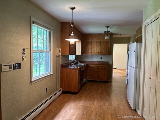 147 Beers Rd, Easton, CT 06612 - kitchen with freestanding refrigerator, a baseboard radiator, brown cabinetry, and a ceiling fan