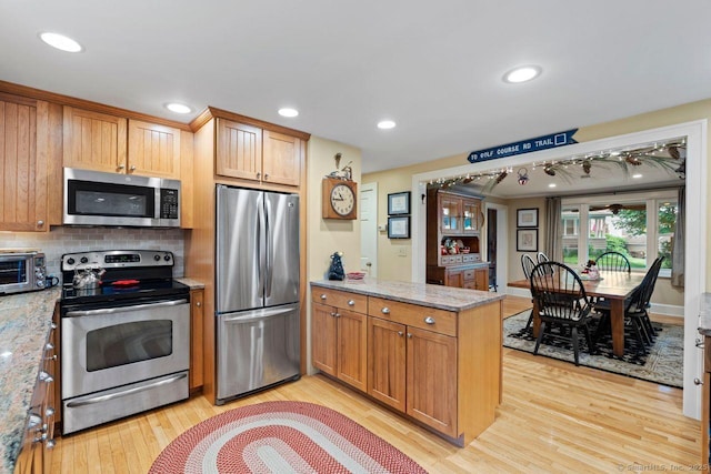 160 Disbrow St, Stratford, CT 06614 - kitchen with appliances with stainless steel finishes, a peninsula, light wood finished floors, tasteful backsplash, and light stone countertops
