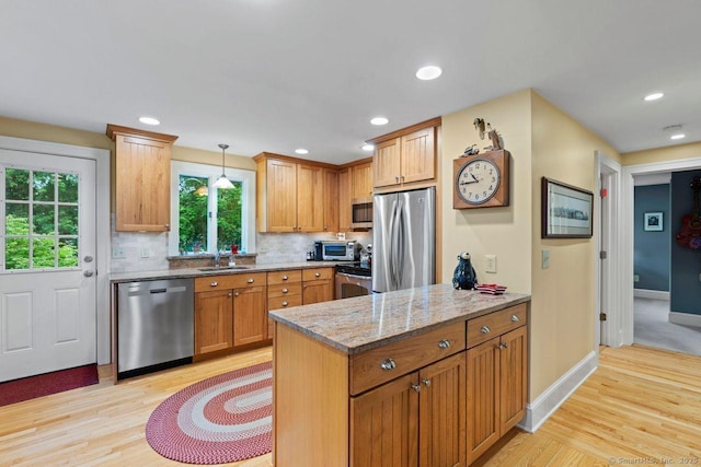 160 Disbrow St, Stratford, CT 06614 - kitchen with appliances with stainless steel finishes, light wood-type flooring, light stone counters, pendant lighting, and decorative backsplash