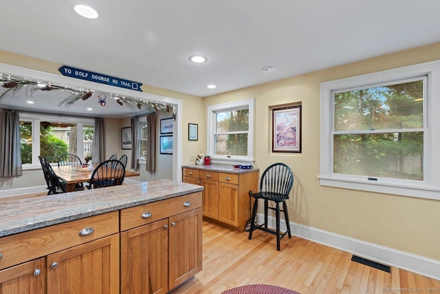 160 Disbrow St, Stratford, CT 06614 - kitchen featuring brown cabinetry, light wood finished floors, light stone counters, and recessed lighting