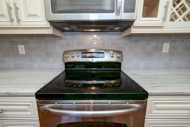 690 Forest Rd Unit 394, West Haven, CT 06516 - kitchen featuring stainless steel appliances, tasteful backsplash, light stone counters, and white cabinets
