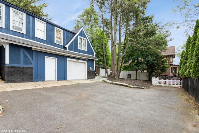 26 Trowbridge St, Waterbury, CT 06710 - view of front of home with driveway, a garage, and brick siding