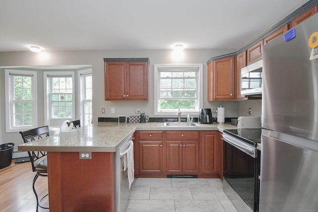 31 Bristol St, Thomaston, CT 06787 - kitchen with stainless steel appliances, a peninsula, a kitchen breakfast bar, brown cabinets, and tile countertops