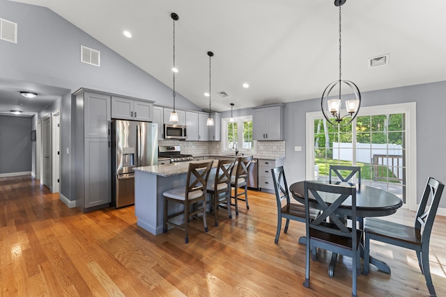 46 Airport Rd, Killingly, CT 06239 - kitchen with appliances with stainless steel finishes, gray cabinets, a kitchen island, a chandelier, and a kitchen bar