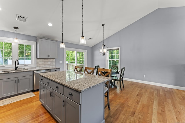 46 Airport Rd, Killingly, CT 06239 - kitchen featuring gray cabinetry, stainless steel dishwasher, vaulted ceiling, a kitchen breakfast bar, and light wood-style flooring