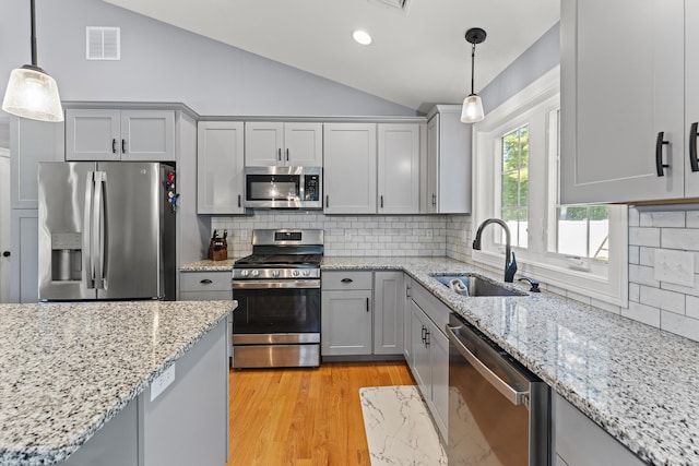 46 Airport Rd, Killingly, CT 06239 - kitchen with appliances with stainless steel finishes, gray cabinetry, lofted ceiling, decorative backsplash, and pendant lighting