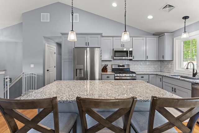 46 Airport Rd, Killingly, CT 06239 - kitchen featuring stainless steel appliances, lofted ceiling, a breakfast bar, gray cabinets, and light stone countertops