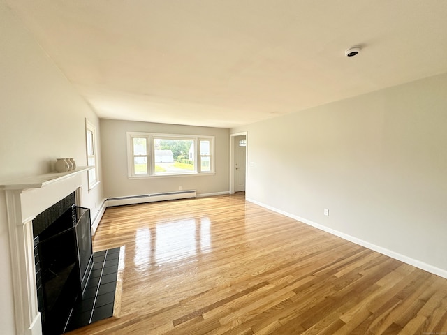 462 Halfway House Rd, Windsor Locks, CT 06096 - unfurnished living room featuring a baseboard heating unit, a tiled fireplace, and light wood finished floors