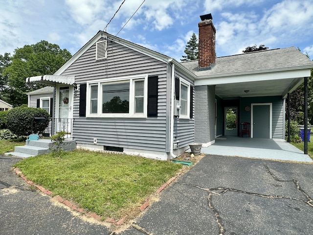 462 Halfway House Rd, Windsor Locks, CT 06096 - view of front facade featuring driveway, a chimney, a front yard, and a carport