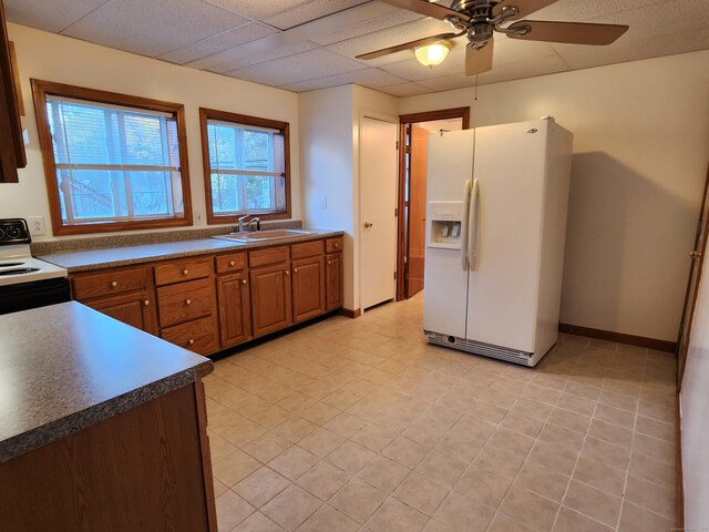 18 Hunters Ave, Norwich, CT 06380 - kitchen with white appliances, a ceiling fan, brown cabinetry, dark countertops, and light tile patterned flooring
