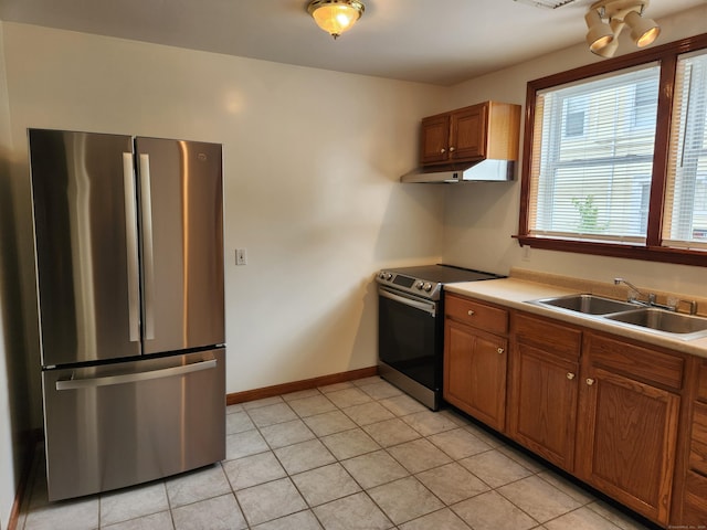 18 Hunters Ave, Norwich, CT 06380 - kitchen featuring appliances with stainless steel finishes, under cabinet range hood, brown cabinetry, light tile patterned floors, and light countertops
