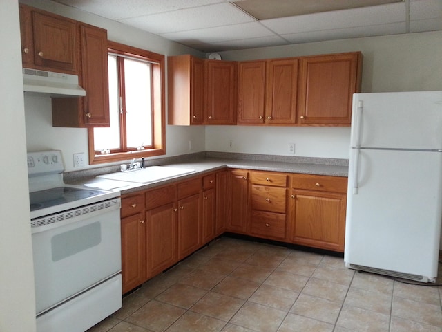 18 Hunters Ave, Norwich, CT 06380 - kitchen with white appliances, under cabinet range hood, light tile patterned floors, brown cabinets, and a drop ceiling