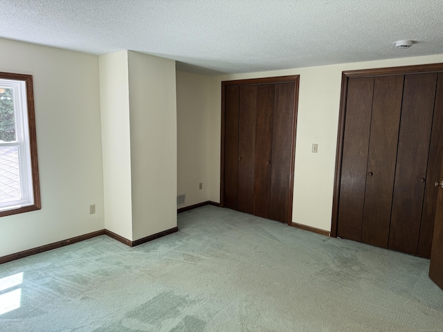 394 Merrow Rd, Coventry, CT 06238 - unfurnished bedroom with light carpet, two closets, and a textured ceiling