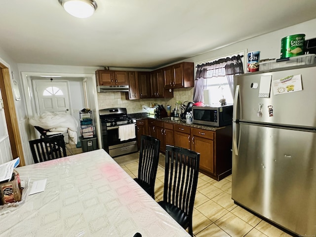 182 Oak St, Waterbury, CT 06704 - kitchen featuring stainless steel appliances, under cabinet range hood, light tile patterned floors, and decorative backsplash