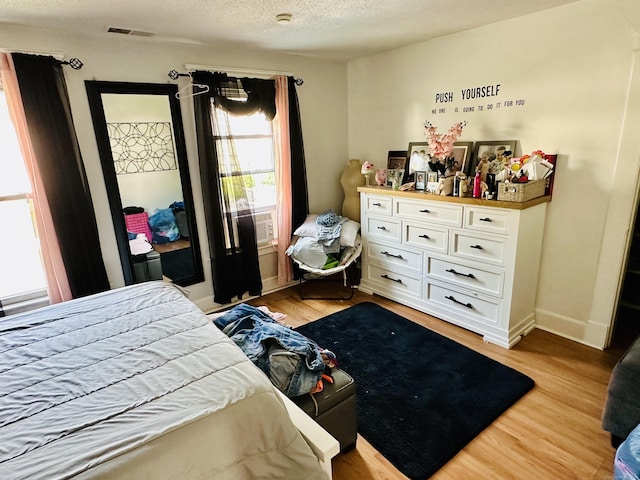 182 Oak St, Waterbury, CT 06704 - bedroom with light wood-style floors, a textured ceiling, and cooling unit