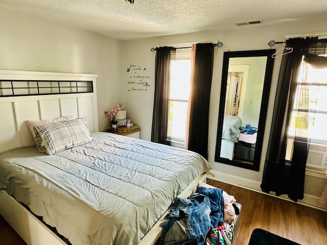 182 Oak St, Waterbury, CT 06704 - bedroom featuring multiple windows, a textured ceiling, and wood finished floors