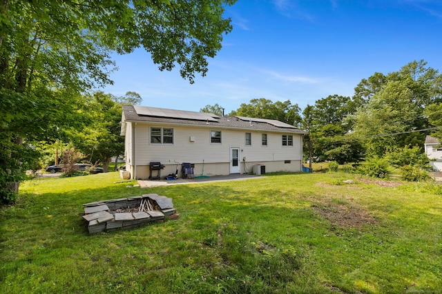 107 Carroll Rd, Hamden, CT 06517 - rear view of property with an outdoor fire pit, solar panels, a patio, and a lawn