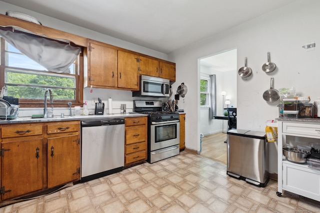 107 Carroll Rd, Hamden, CT 06517 - kitchen featuring appliances with stainless steel finishes, brown cabinetry, light floors, and light countertops