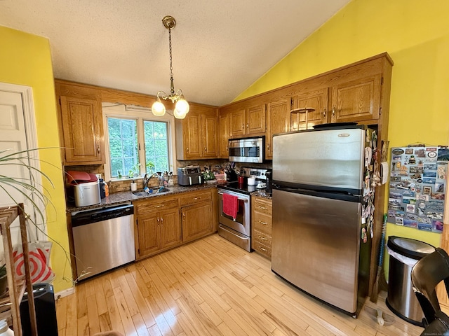 175 Berlin Ave Apt 31, Southington, CT 06489 - kitchen with appliances with stainless steel finishes, brown cabinets, backsplash, vaulted ceiling, and light wood-type flooring